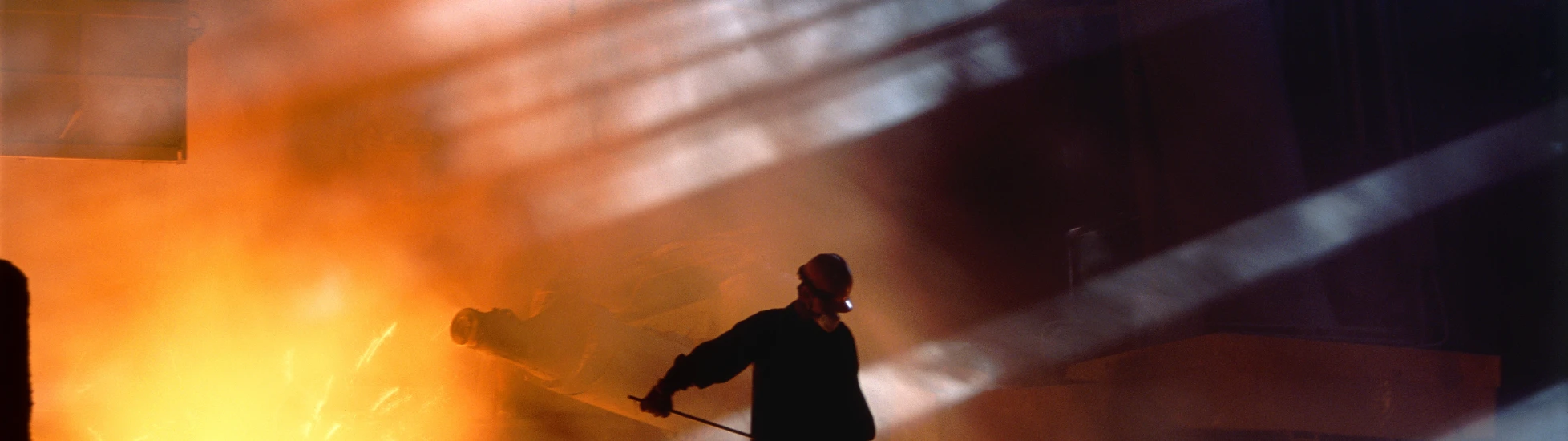 Smelting worker moving ore in landscape shot