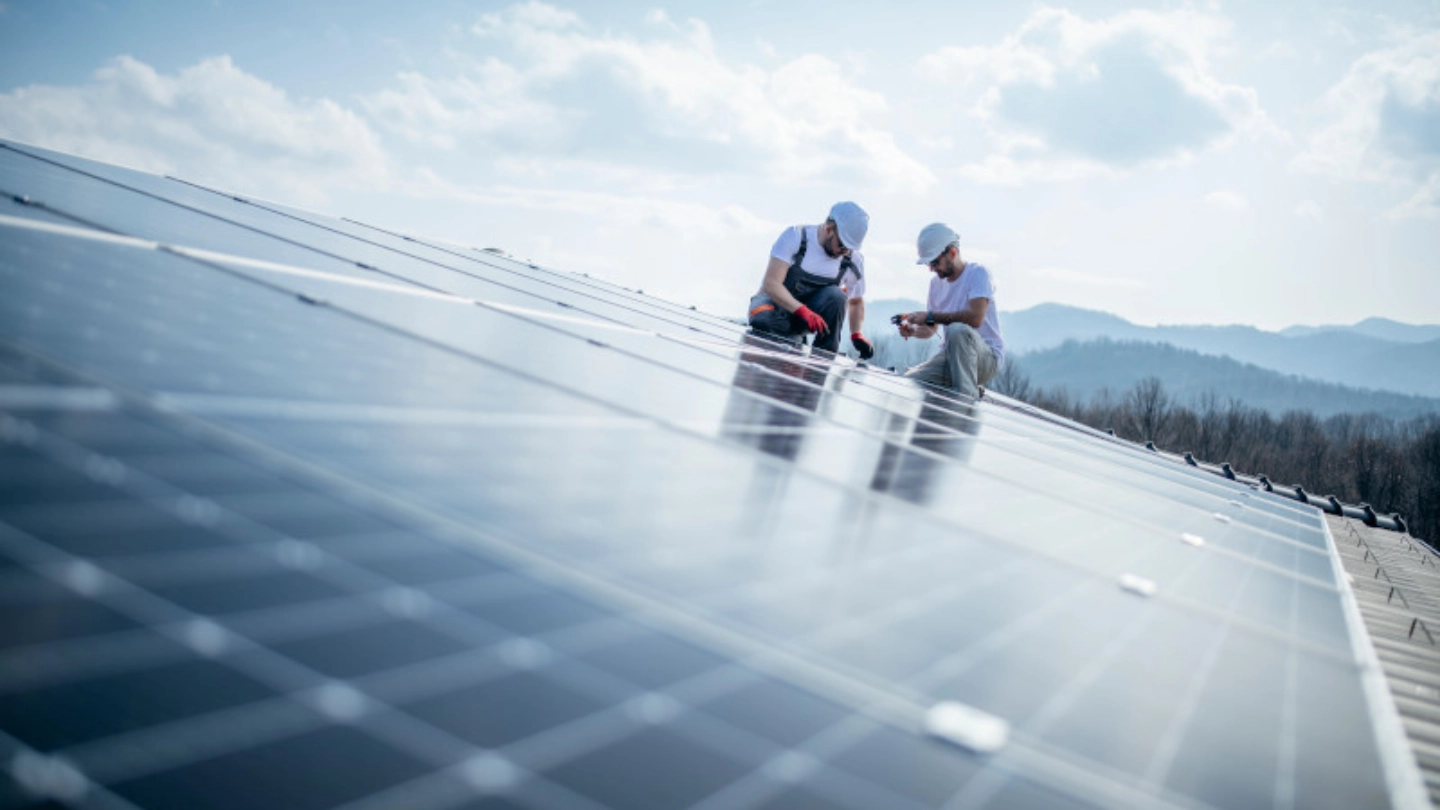 two men on solar panel roof image