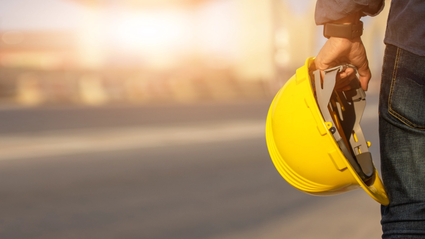 Construction worker holding safety helmet Construction worker holding safety helmet