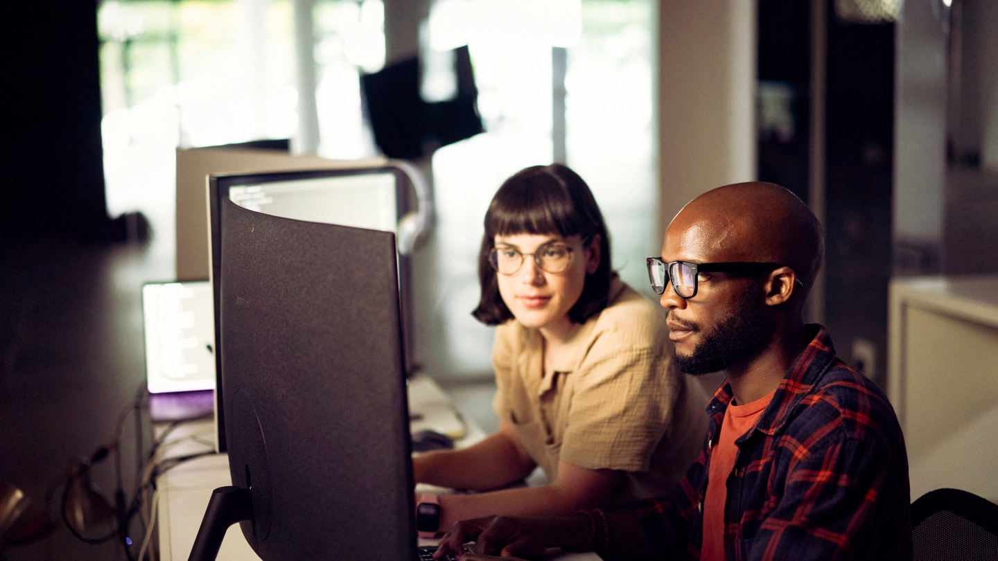 Male and female compute analysts working in front of computer image