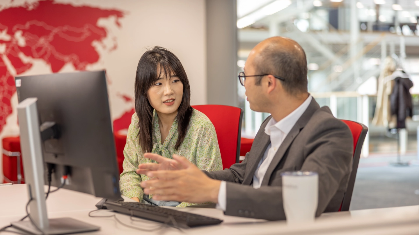 Woman and man discussing closely behind a desk (1) image