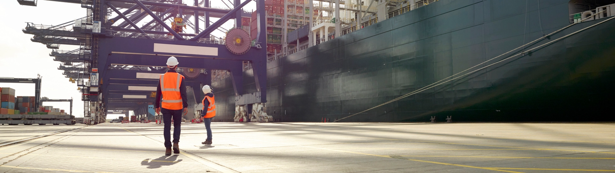 Dock workers beside cargo ship at Port of Felixstowe, England