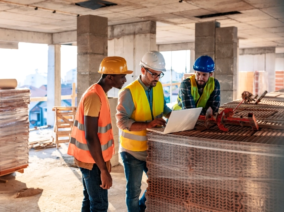 Construction workers on a building site reviewing site plans